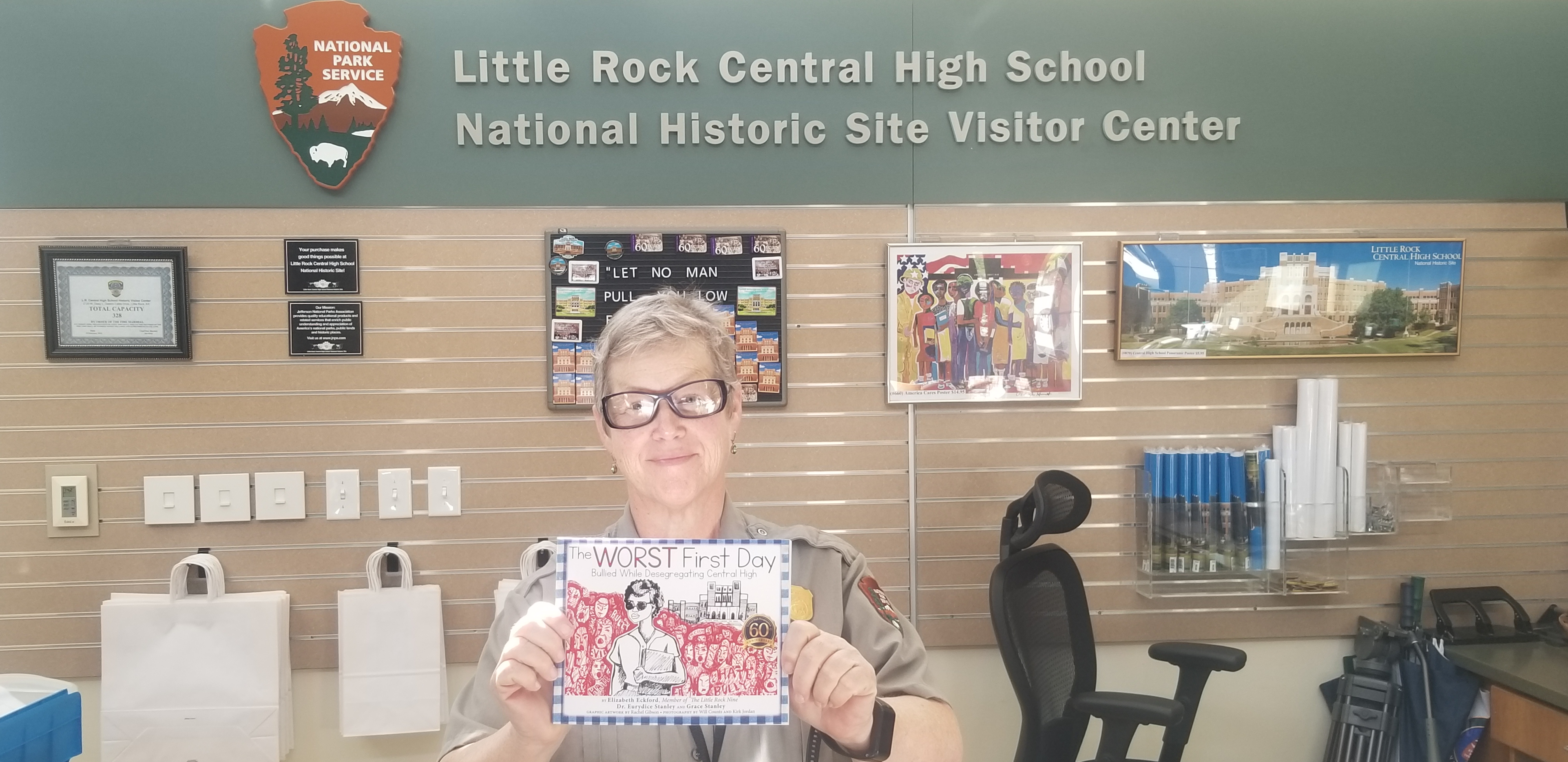 Woman at little rock central high school holding book 