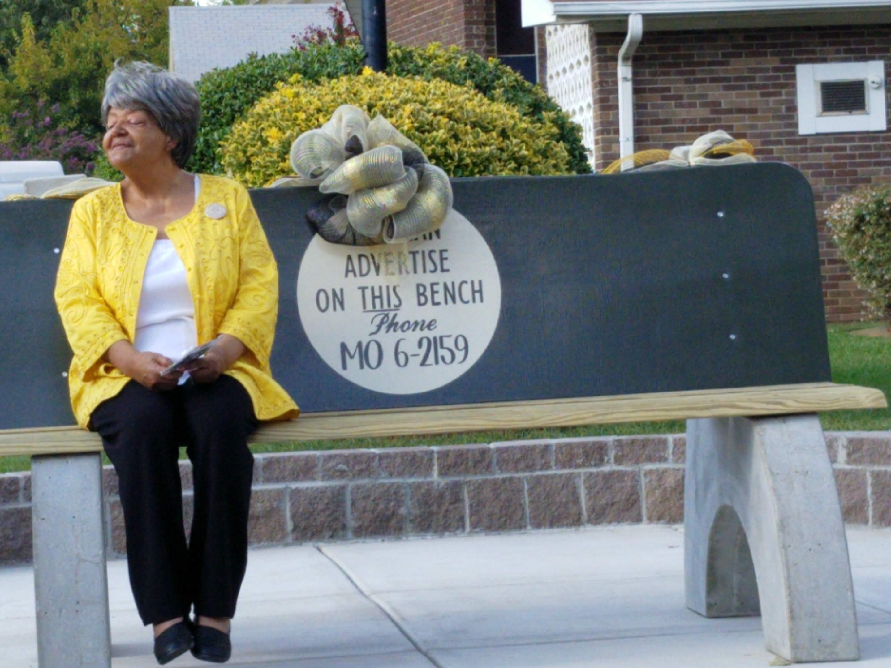 Elizabeth Eckford sitting on commemorative bench